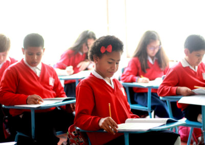 niña estudiando uniforme rojo